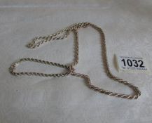 A silver neck chain and a silver bracelet,