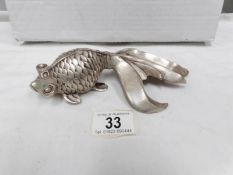 A silver plated paperweight in the shape of a fish