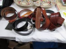 A quantity of leather belts and a leather purse