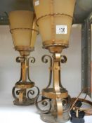 A pair of wrough metal table lamps with glass shades