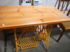 A painted treadle sewing machine base with pine table top