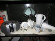 A shelf of miscellaneous including radio, lamps.