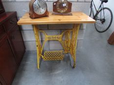 A Singer treadle sewing machine base converted to a table with pine top