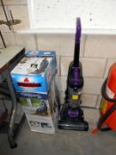 A Bissell bag less upright vacuum cleaner and one other