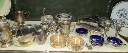 A shelf of assorted metal ware including wine coasters