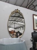 An oval brassed framed mirror