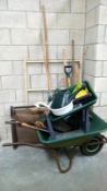 A large quantity of garden tools including wheelbarrow