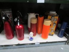 A shelf of soda syphons and vacuum flasks