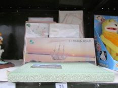 A quantity of boxed table linen & Santa Maria new boxed wood ship