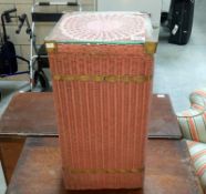 A lloyd loom style linen bin with glass top insert
