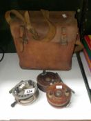 A Leather fishing bag and 3 old fishing reels including Decantelle