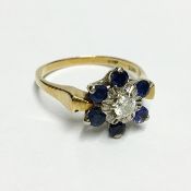 A sapphire and diamond snowflake shaped cluster ring in 18ct gold with 6 sapphires and 1 diamond,