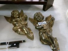 A pair of brass cherubs