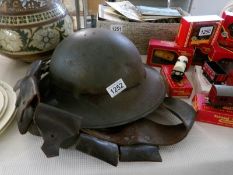 A civil defence grey Zukerman helmet marked 'L' with inner liner and a leather bandoleer belt