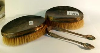 2 silver backed brushes and a pair of silver sugar nips