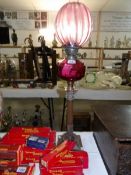 A Corinthian column oil lamp with cranberry glass font