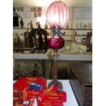 A Corinthian column oil lamp with cranberry glass font