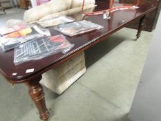 A mahogany extending dining table with 2 leaves and on reeded legs