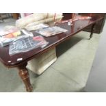 A mahogany extending dining table with 2 leaves and on reeded legs