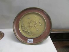 A brass comport with embossed cherub scene