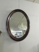 An oval framed bevel edged mirror