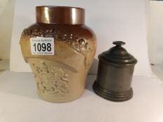 A 19th century coat of arms tobacco jar and a pewter tobacco jar