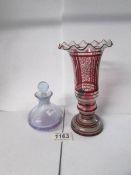 A red patterned glass vase and a glass scent bottle