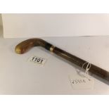 A walking stick with horn handle and gold band