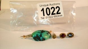 A pair of gold stud earrings set garnet and a natural turquoise stone formed in to a brooch with