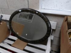 An oval framed bevel edged mirror