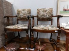A pair of oak elbow chairs with tapestry seats and backs