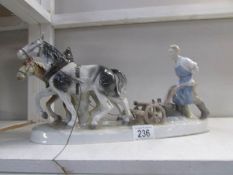 A pair of ceramic horses pulling a plough