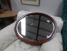 An oval mahogany framed bevel edged mirror