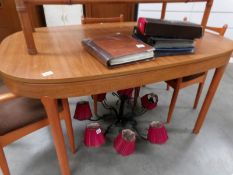 An oval teak dining table and 2 chairs