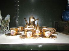 A gold coloured coffee set with classical scenes