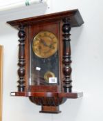 A wall clock in mahogany case complete with key and pendulum but finials missing