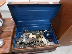 A large quantity of oil lamp parts in a tin trunk