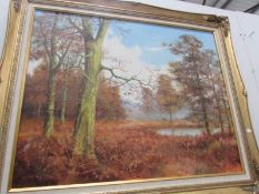 An oil on canvas of an autumn woodland and lake signed Bill Makinson