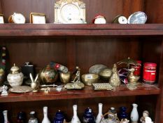 A shelf of brass ornaments etc