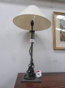 A wrought iron table lamp with shade