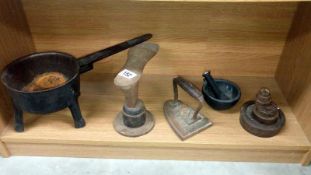 A cast iron pan, a shoe last, flat iron, pestle and mortar,