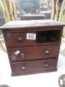A miniature chest of drawers,