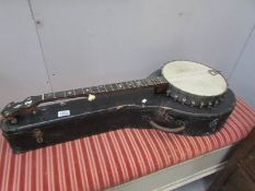 A cased banjo with mother of pearl inlay