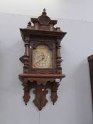An oak cased wall clock with brass dial