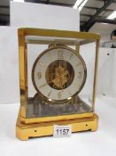 A brass and glass cased clock marked Le Coutre Atmos, Fifteen jewels, Switzeland,