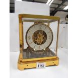 A brass and glass cased clock marked Le Coutre Atmos, Fifteen jewels, Switzeland,