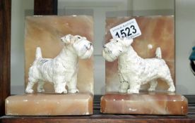 A pair of art deco book ends surmounted dogs