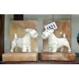 A pair of art deco book ends surmounted dogs