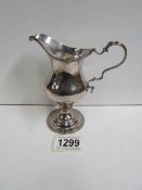A George III silver cream jug with beaded rim,