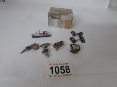 A small mother of pearl box containing a collection of interesting badges (some silver)